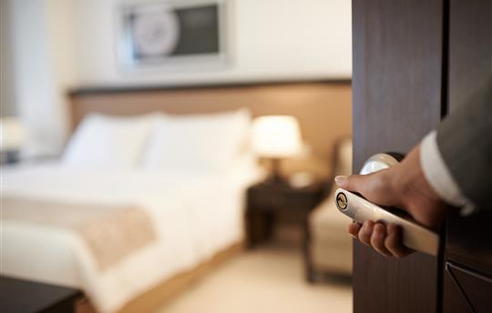 hand opening door to hotel room