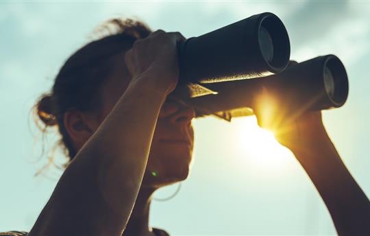 woman looking through binoculars