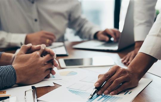 office workers discussing charts and graphs