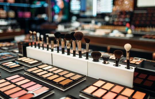 makeup and brushes on beauty counter at store