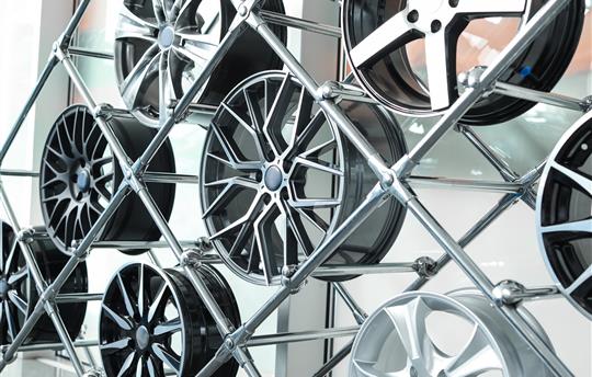 Different automotive wheels on stand in auto shop