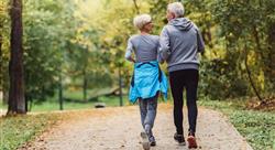 Cheerful active senior couple jogging in the park