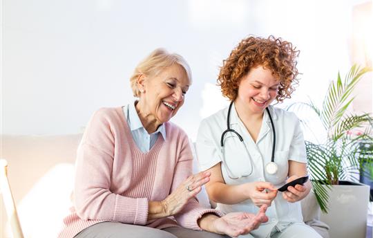 healthcare provider helping woman test blood sugar levels