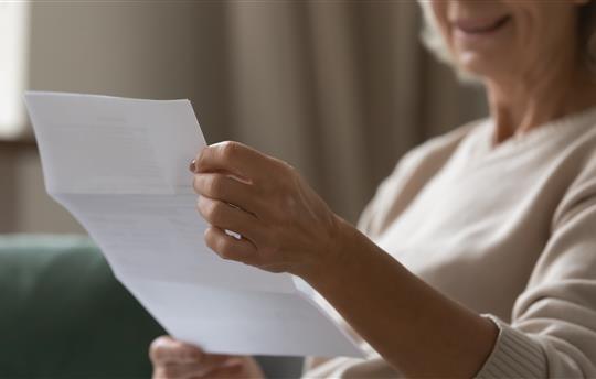 elderly woman reading bill or medical statement