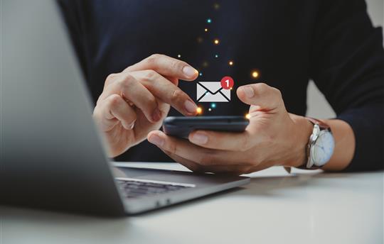 person checking email on phone with email graphic