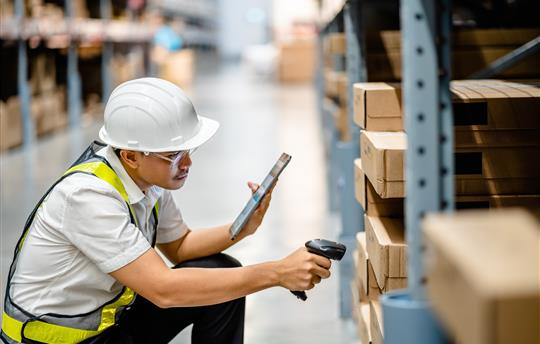 Warehouse workers use scanner checking and scan the barcode of stock inventory to keep storage in a
