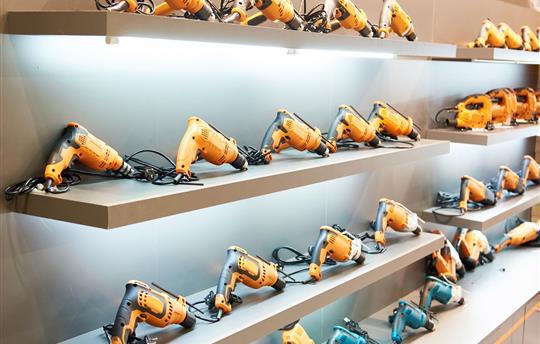hardware store display shelf filled with orange power drills