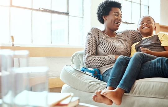 mother and son sitting and laughing together on the couch