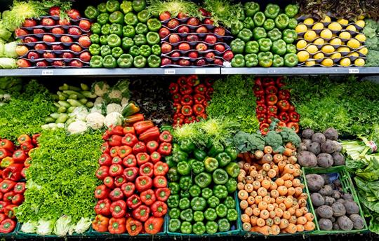 A variety of fruits and vegetables neatly on display in the produce section of a grocery store