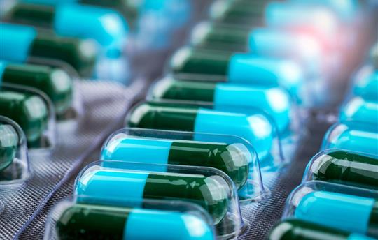 tray of blue-green medication capsules