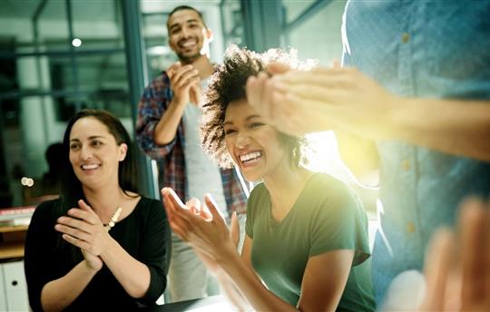 Shot of a team of creative and diverse businesspeople applauding an achievement while working late in the boardroom