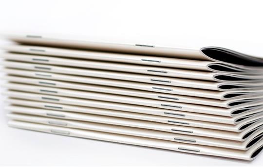 stack of white magazines with saddle stitch binding