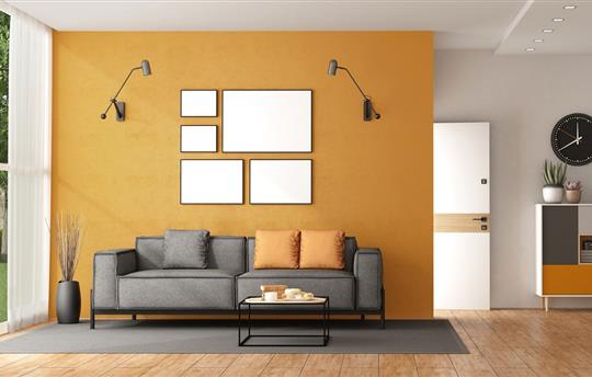 modern living with gray couch in front of yellow wall