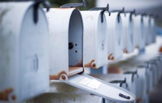 mailbox open in row of white mailboxes