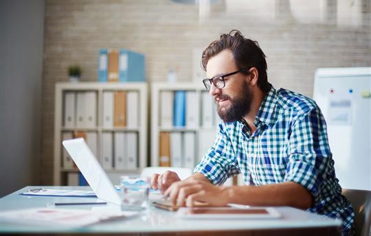 casual man typing on laptop
