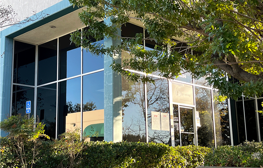 Front entrance to TO Printing facility with trees and shrubs