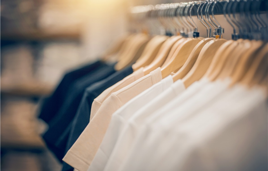t-shirts on hangers inside a clothing store