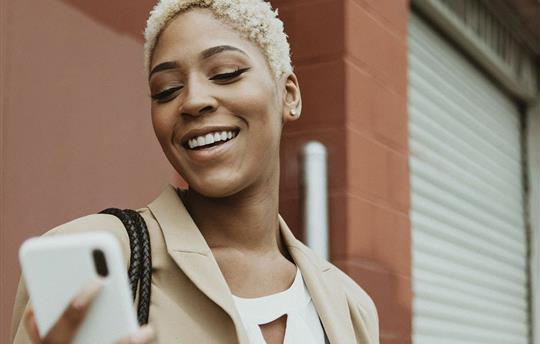 woman looking at her smartphone and smiling
