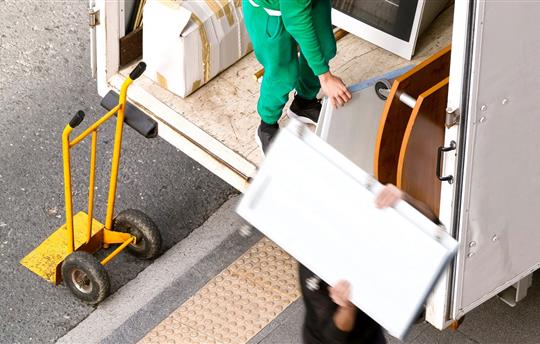 Two movers taking furniture out of a moving truck